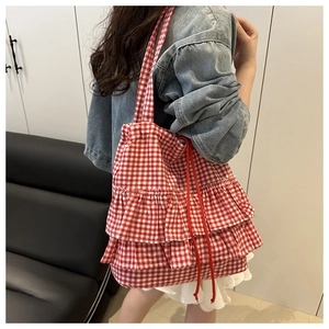 Detail of red and white plaid tote bag featuring multi-layer ruffles and drawstring