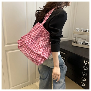 Detail shot of pink and white checkered tote bag with elegant ruffled pleats on side