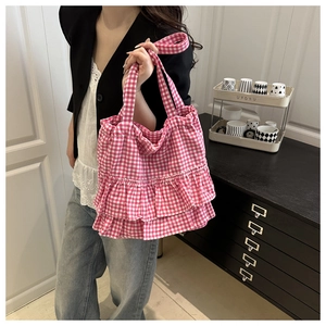 Detail of pink and white checkered tote bag with double ruffled edges and fabric texture