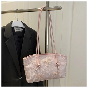 Détail d'un sac cabas rose en dentelle avec papillons 3D et doubles poignées en corde