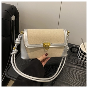 Detail of canvas and silver leather patchwork shoulder bag with gold square buckle lock