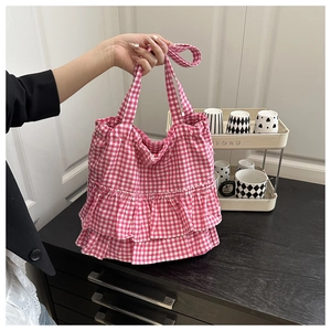 Detail view of pink gingham tote bag featuring triple-layered ruffled skirt design