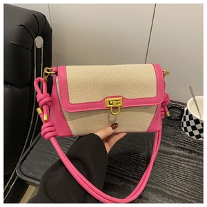 Detail of pink leather and beige canvas baguette bag with golden clasp and knotted strap