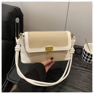Detail of canvas leather patchwork bag with gold buckle and white rope shoulder strap
