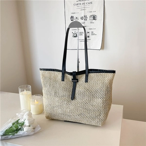 Fashionable woven straw tote bag with black leather straps and large capacity for beach