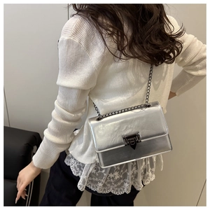 Detailed back view of a silver metallic chain crossbody bag with black metal clasp