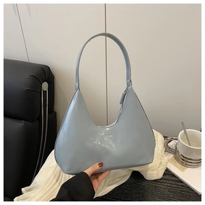 Close-up of light blue patent leather hobo bag with high-gloss finish and sleek shoulder strap