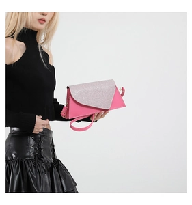 Détail du sac asymétrique fuchsia avec rabat pailleté argenté et boucles en métal