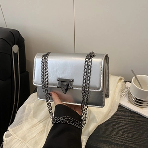 Metallic silver square crossbody bag with black chain strap and turn-lock closure