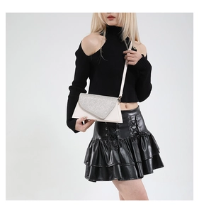 Vue détaillée du sac enveloppe avec paillettes argentées et cuir crème élégant