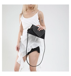 Détail de la pochette de soirée noire avec rabat pailleté et coutures blanches