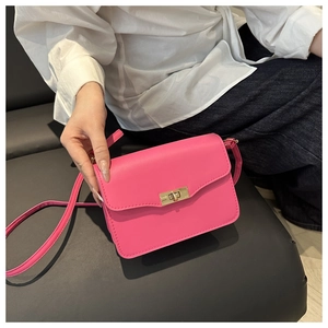 Close-up of bright pink faux leather crossbody bag with elegant golden twist lock buckle
