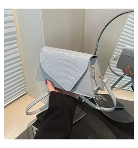 Détail du sac bandoulière argenté avec rabat incrusté de diamants et finition en cuir lisse