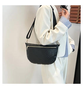 Détail du sac bandoulière noir à texture tissée avec sangle et fermeture éclair dorée