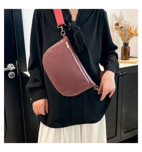 Détail du sac bandoulière tissé bordeaux avec large sangle et fermetures éclair dorées