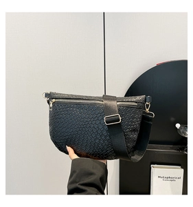 Détail de la texture tissée noire sur le sac croissant avec fermeture éclair dorée