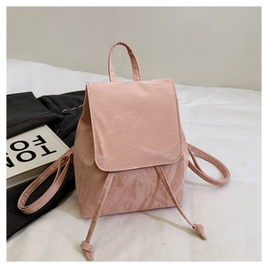 Detail of light pink mini backpack featuring unique crinkled texture and drawstring closure