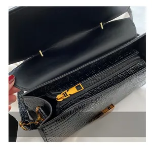 Detail of premium crocodile embossed black handbag with smooth golden zipper and inner pocket