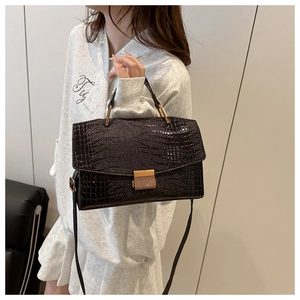 Détail du sac à main gaufré crocodile foncé avec ferrures dorées et boucle en métal