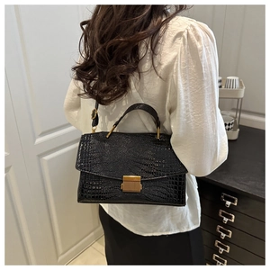 Sac bandoulière noir texture crocodile avec fermoir doré en situation de vie réelle