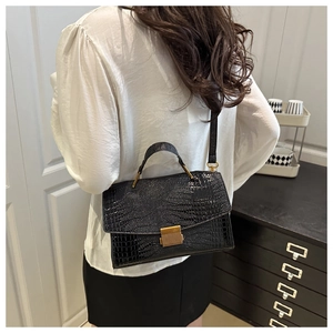 Back view of a chic black crocodile embossed shell bag with gold hardware and shoulder strap