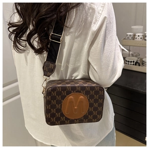 Brown vintage camera bag with embossed M logo and adjustable patterned wide shoulder strap