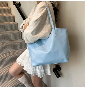 Close-up of light blue large capacity leather tote bag with stylish long shoulder straps