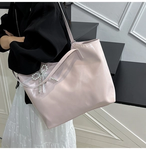 Dettaglio della borsa tote rosa chiaro con fiocco di perle e nastro di pizzo bianco