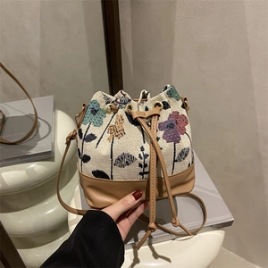 Retro floral jacquard bucket bag with brown leather trim and drawstring closure
