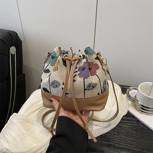 Retro floral jacquard bucket bag with brown leather drawstring and gold hardware