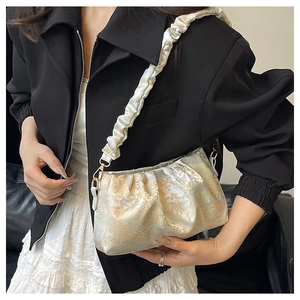 Detailansicht der champagnergoldenen Jacquard-Tasche mit plissiertem Schultergurt