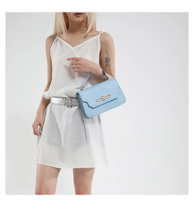 Detail of light blue leather handbag with gold metal clasp and sleek top handle