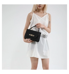 Close-up of elegant black leather handbag with classic gold metal clasp and top handle