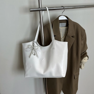 Minimalist white tote bag with pearl bow pendant and adjustable strap for spring