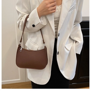 Close-up of brown litchi pattern leather shoulder bag with silver zipper detail