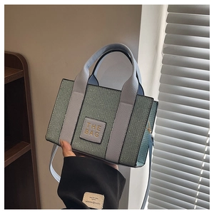 Détail du sac cabas en tweed bleu et menthe avec texte doré et bandoulière amovible