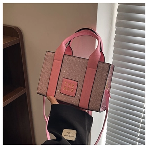 Détail du sac cabas carré rose pailleté avec poignée élégante et bandoulière amovible