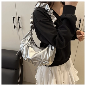 Detail of silver metallic cloud bag with bow accents and pleated strap for women