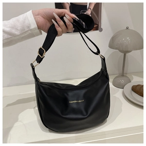 Detail of black hobo bag with golden logo, adjustable strap and matte leather finish