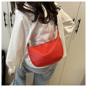 Detailed back view of a red crescent leather shoulder bag with logo on a model