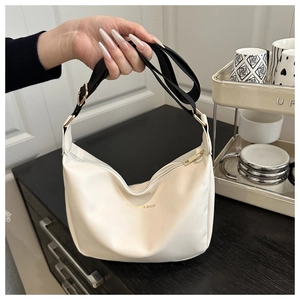 Detail of white hobo bag with gold Fashion & Bags logo and adjustable strap