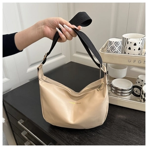 Detail of beige crescent bag with FASHION & BAGS print and wide canvas shoulder strap
