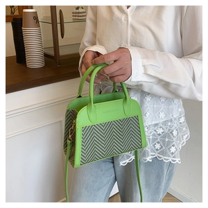 Detail of green contrast color handbag with herringbone texture and FASHION & BAGS logo