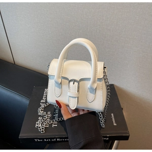 Detailansicht der weißen Mini-Tasche aus Kunstleder mit Silberkette und Metallschnalle