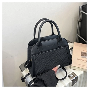 Detail of black leather and woven handbag featuring Fashion & Bags logo engraving