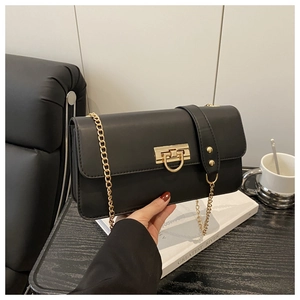 Close-up of black leather rectangular crossbody bag with golden chain and metal buckle