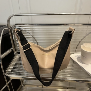 Chic cream hobo shoulder bag with wide strap on display shelf for modern fashion