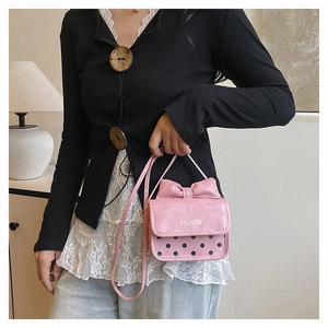 Détail du mini sac bandoulière rose avec nœud 3D, pois et une fine bandoulière en cuir