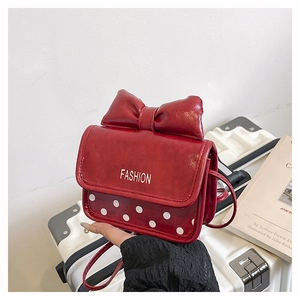 Vue détaillée du mini sac bandoulière rouge avec pois blancs et grand nœud décoratif chic