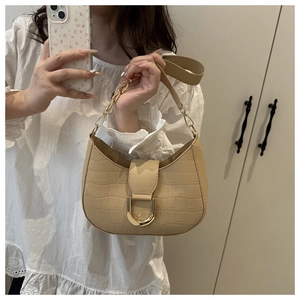 Detail van beige hobo-tas met krokodillenpatroon en gouden U-vormige gesp ter decoratie